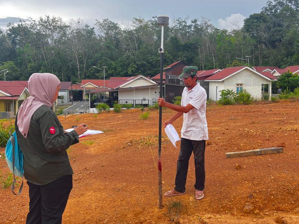 Petugas Kantah Balangan melakukan pengukuran tanah di lapangan