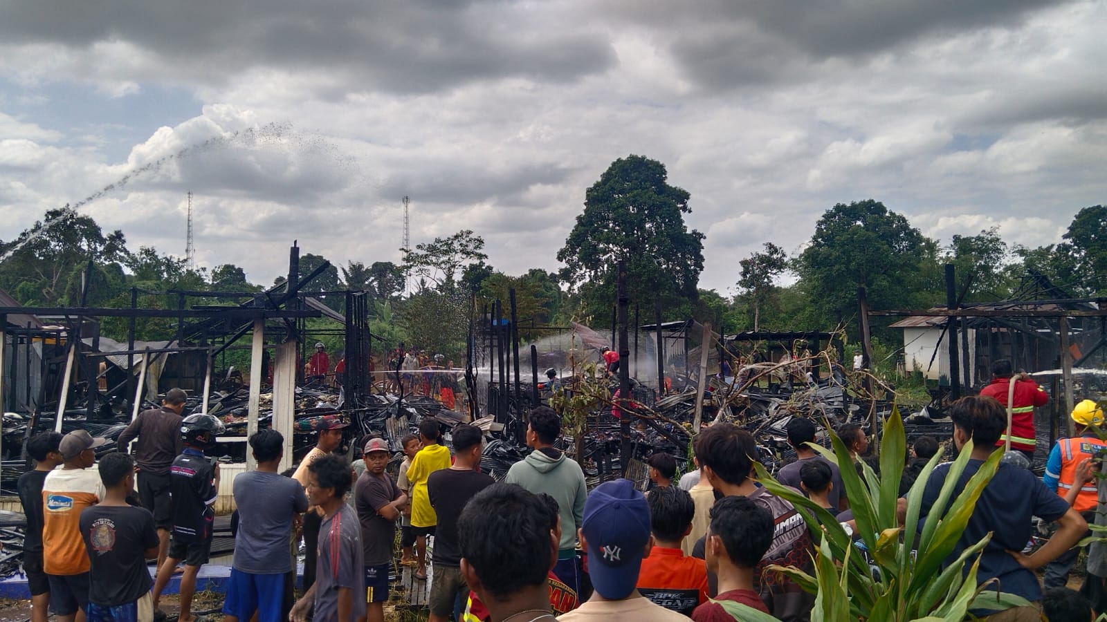 Petugas pemadam kebakaran memadamkan api yang membakar enam rumah di Desa Pingaran Ilir, Astambul.