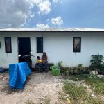Nana duduk di depan rumah yang ditempatinya bersama dua anaknya di tengah sengketa lahan di Banjarbaru.