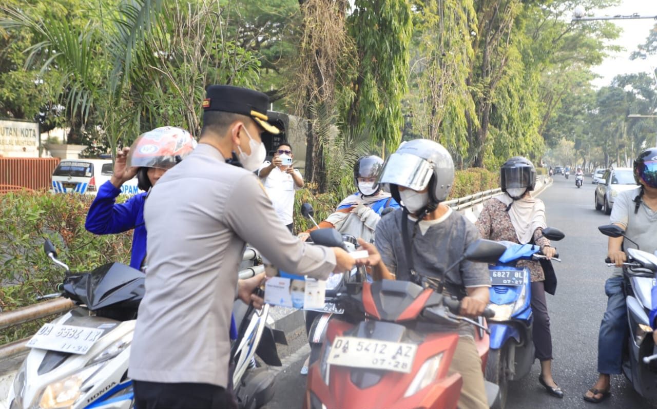 Kapolresta Banjarmasin Riza Muttaqin membagikan masker kepada pengguna jalan di tengah kabut asap karhutla